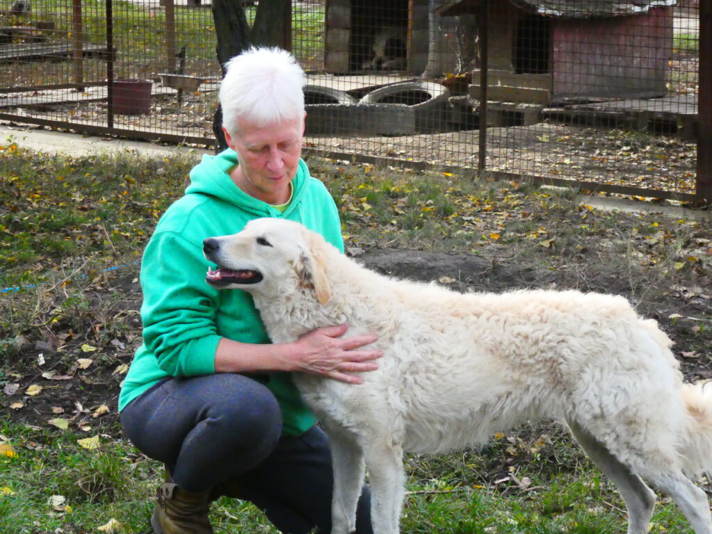 Frau umarmt weißen Hund